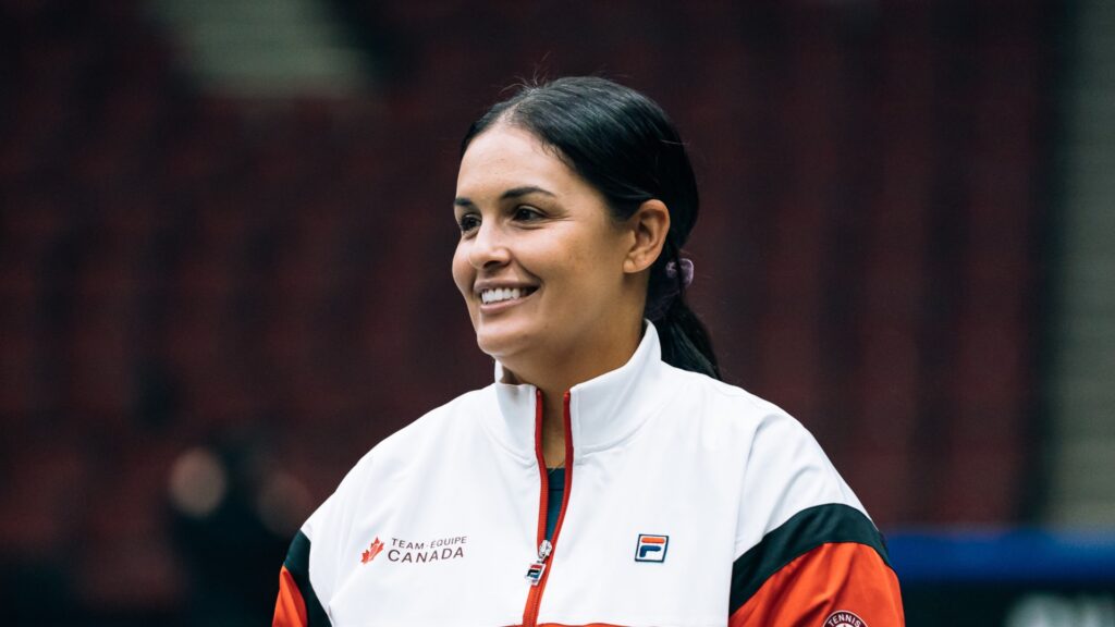 Heidi El Tabakh stands on the court and smiles.