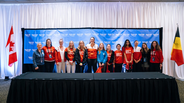 Members to Team Canada pose for a photo in the press room with local girls.