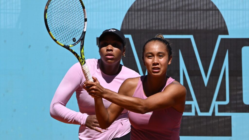 Leylah Fernandez follows through on a volley with Taylor Townsend standing behind her.