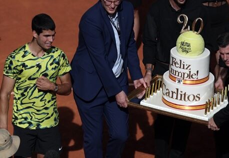 Carlos Alcaraz receives a large birthday cake on court.