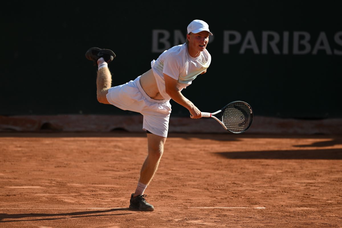 Keegan Rice hits serve at Roland-Garros