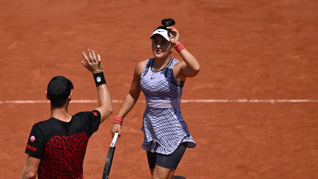 Bianca Andreescu (facing) high fives Michael Venus.