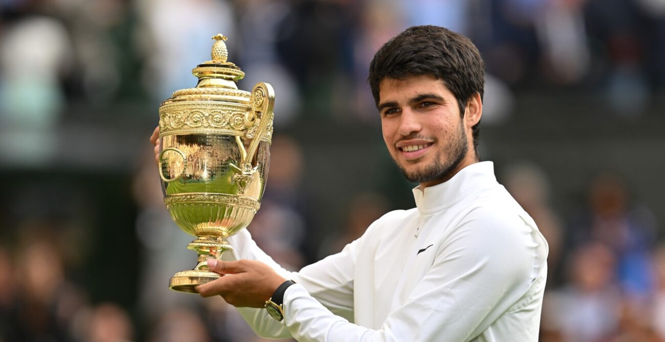 Carlos Alcaraz holds up the Wimbledon trophy.