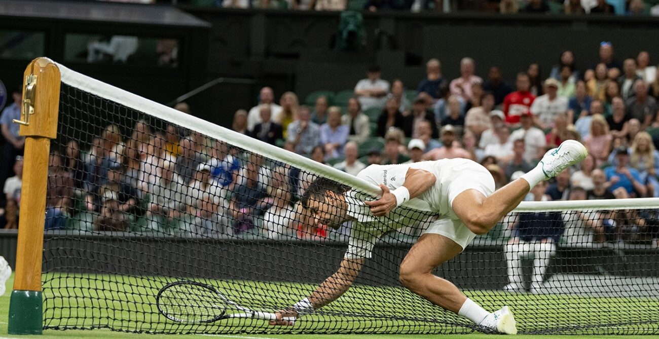 Novak Djokovic falls over the net at Wimbledon.