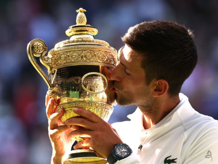 Novak Djokovic kisses the Wimbledon trophy