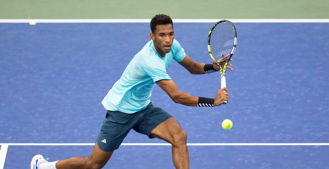 Felix Auger-Aliassime reaches for a backhand volley.