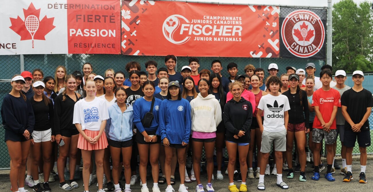 Players stand in front of a Junior Nationals sign.