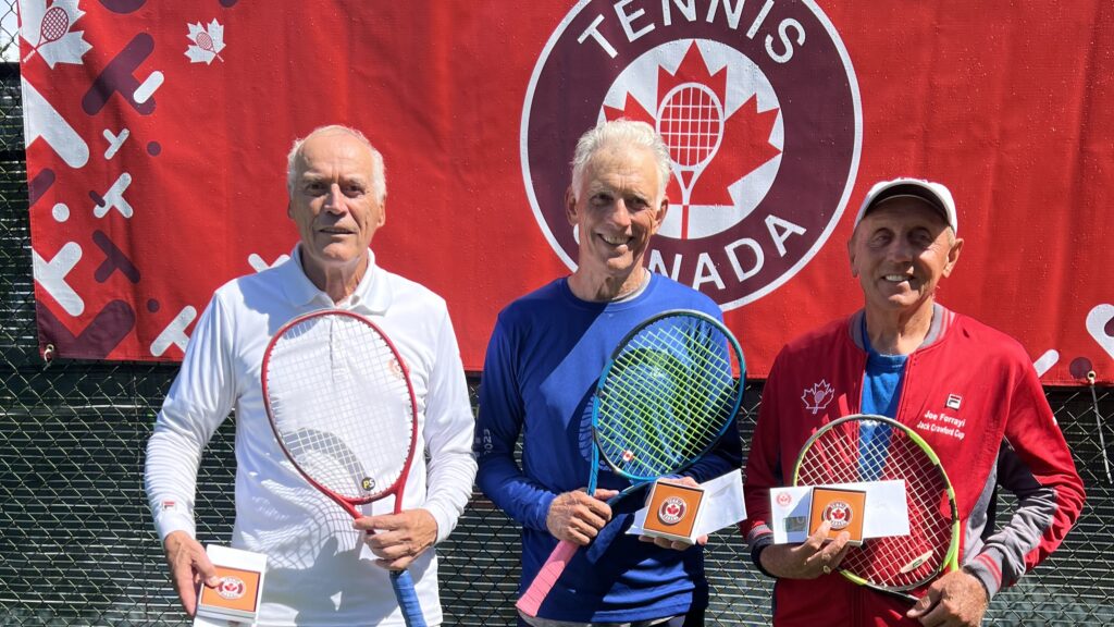Three men hold their rackets and prizes in front of the Tennis Canada logo.