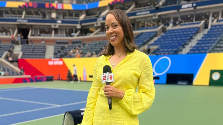 Alexandra Steveson stands in front of Centre Court holding a microphone.