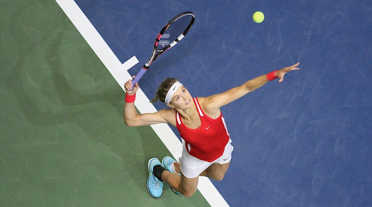 Overhead shot of Eugenie Bouchard tossing a ball up and preparing to hit a serve.