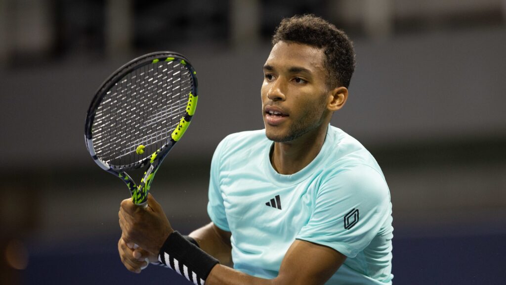 Felix Auger-Aliassime follows through on a backhand and watches his shot.