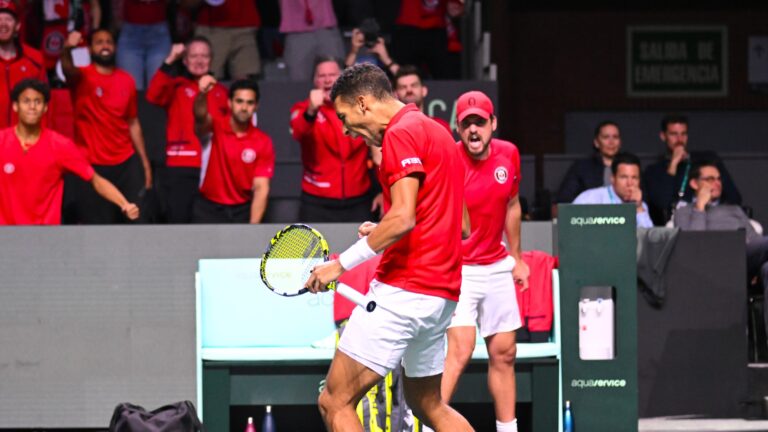 Felix Auger-Aliassime pumps his fist with Frank Dancevic and Team Canada cheering in the background at the Davis Cup.