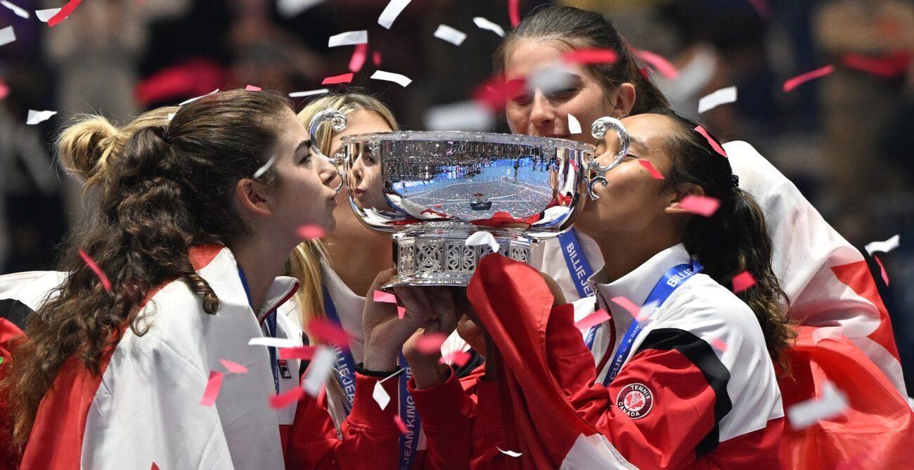 Marina Stakusic (left) and Leylah Fernandez (right) kiss the Billie Jean King Cup trophy.
