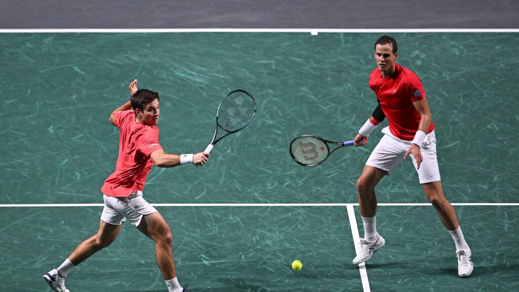 Alexis Galarneau hits a volley while Vasek Pospisil looks on during a match for Team Canada at the Davis Cup.