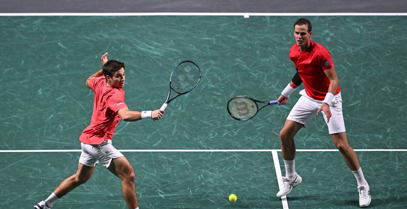 Alexis Galarneau hits a volley while Vasek Pospisil looks on during a match for Team Canada at the Davis Cup.