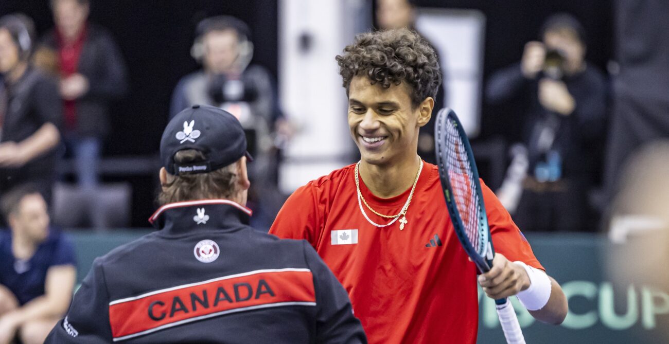 Gabriel Diallo smiles and prepares to hug Frank Dancevic (back to camera) after Canada defeated Korea at the Davis Cup.