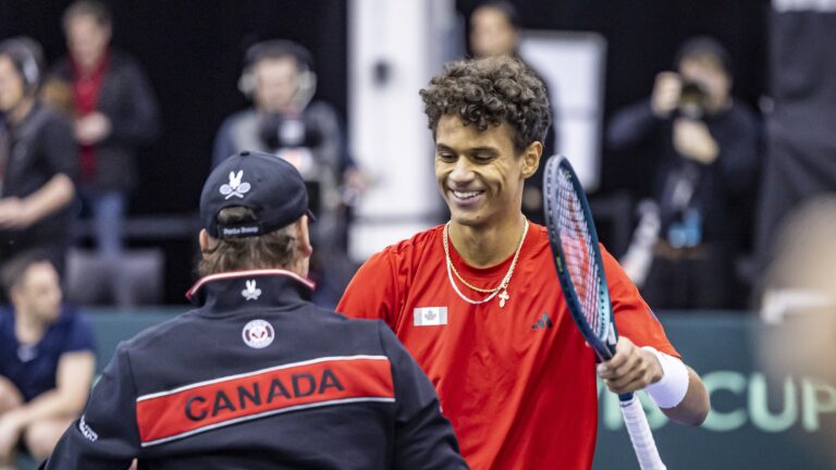 Gabriel Diallo smiles and prepares to hug Frank Dancevic (back to camera) after Canada defeated Korea at the Davis Cup.