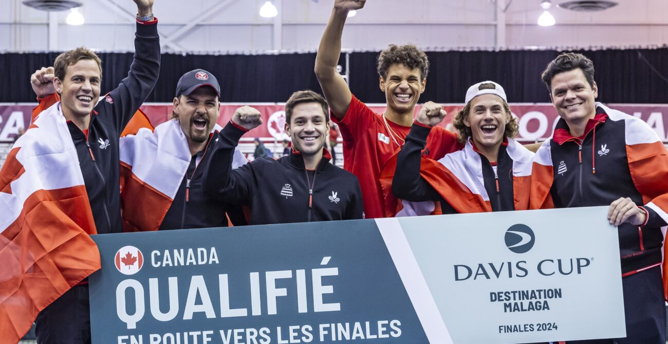 Team Canada holds up a "Qualified" sign after Gabriel Diallo won the clinching match at the Davis Cup.