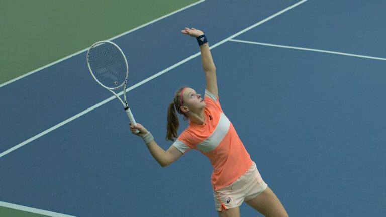 Alice Robbe tosses a ball up to serve. She and Jessie Aney are the top seeds in Montreal.