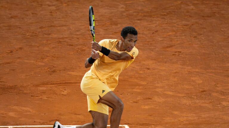 Felix Auger-Aliassime follows through on a backhand on a clay court. He played Botic van de Zandschulp in his opening match in Rome on Saturday.
